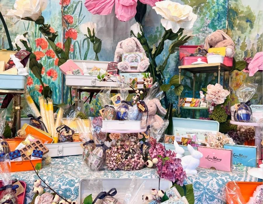 Colorful gift display at The Paris Market featuring gourmet chocolates, pastel gift boxes, plush bunnies, wrapped treats, and elegant spring-themed decor in a whimsical boutique setting.